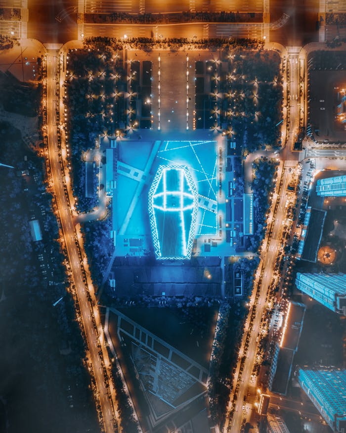 A breathtaking aerial view of a modern cityscape at night with mesmerizing blue and yellow lights.