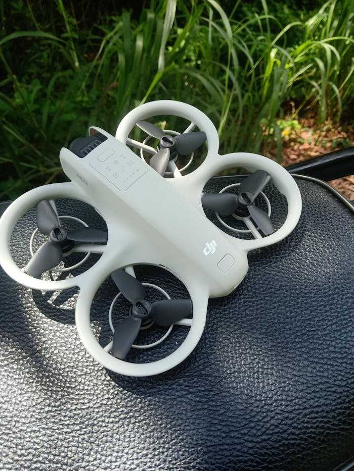 Crafting Captivating Headlines: Your awesome post title goes here Small white drone with propeller guards on a black texture outdoor surface.